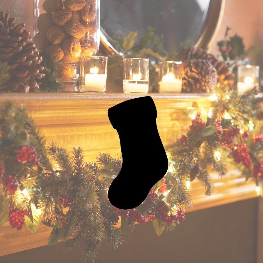Christmas stocking glass precut on holiday mantle with candles, pinecones, greenery, and festive lights.