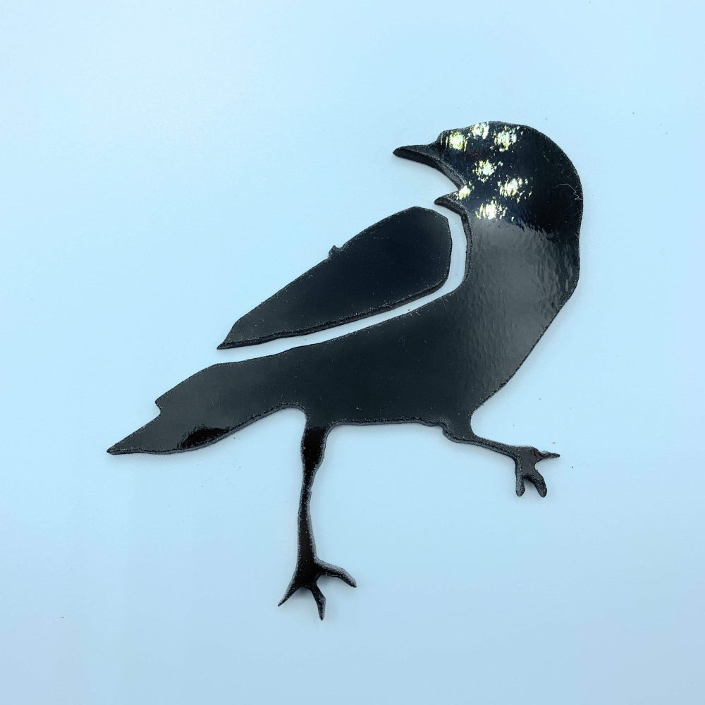 Precut glass shape of a raven in black glass.