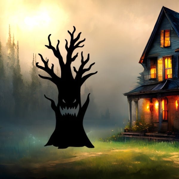 A Halloween-themed Bullseye COE 90 glass precut tree with gnarled limbs and a toothy expression looms in front of a misty haunted house. The foggy backdrop and eerie orange windows set the perfect scene for fused glass art.